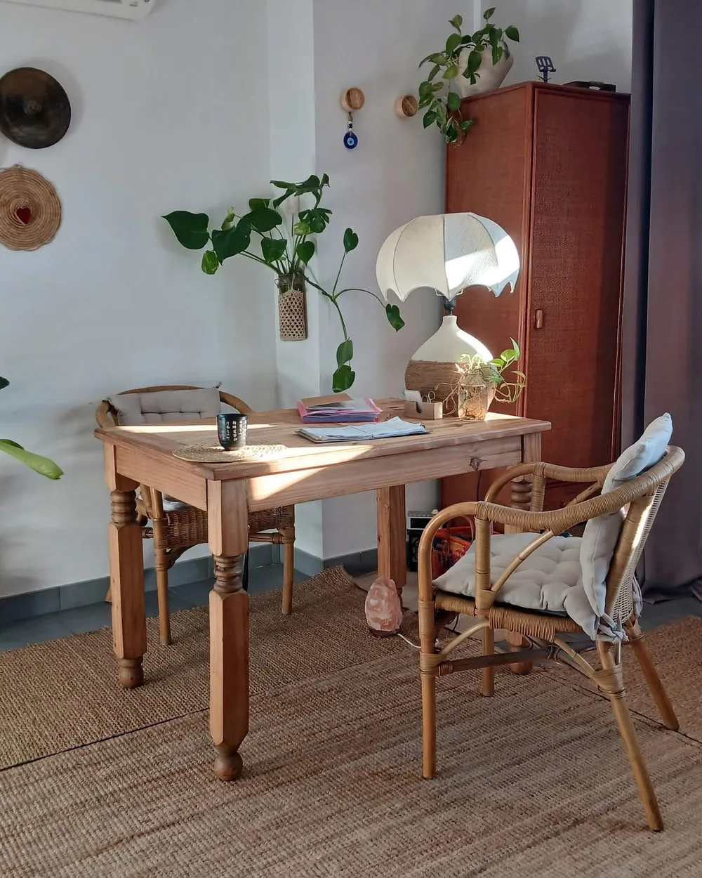Espace d'accueil du cabinet de massage Mingmen au Thor (84250) : bureau en bois, fauteuil en rotin et plantes