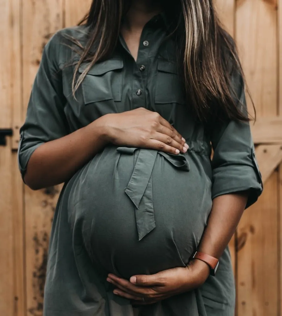 Femme enceinte, les mains posées sur son ventre